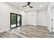 This bedroom features sliding glass doors to balcony, neutral walls, wood look flooring, and ceiling fan at 1045 Jesse Ave, Safety Harbor, FL 34695