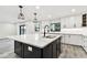 Kitchen island with a marble countertop, black cabinets, and stainless steel dishwasher and sink at 1045 Jesse Ave, Safety Harbor, FL 34695