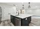Kitchen island featuring a marble countertop, stainless steel dishwasher, and black cabinets at 1045 Jesse Ave, Safety Harbor, FL 34695
