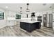 Modern kitchen with stainless steel appliances, black range hood, and a white marble countertop island at 1045 Jesse Ave, Safety Harbor, FL 34695