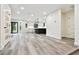 Open-concept living room with wood floors, seamlessly connecting to a contemporary kitchen and leading to the outdoors at 1045 Jesse Ave, Safety Harbor, FL 34695