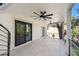 Large patio with sliding glass doors, minimalist railings, and ceiling fans, perfect for outdoor entertaining at 1045 Jesse Ave, Safety Harbor, FL 34695
