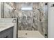 Walk-in shower with marble tile surround, glass door, and white hexagon tile floor at 1045 Jesse Ave, Safety Harbor, FL 34695