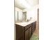 Bathroom with double sinks, dark wood cabinets, and a large mirror at 10943 Verawood Dr, Riverview, FL 33579