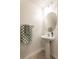 Clean half bathroom with a pedestal sink, oval mirror, and decorative towels at 10943 Verawood Dr, Riverview, FL 33579