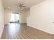Bright and airy living room with wood flooring, ceiling fan, and sliding glass doors to a patio at 10943 Verawood Dr, Riverview, FL 33579