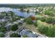 Aerial view featuring a property near a lake, surrounded by lush trees and a well-maintained lawn, offering a tranquil setting at 1204 Joe Henry Wheeler Dr, Dover, FL 33527
