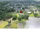 Aerial view of a lakeside house surrounded by lush greenery and neighboring homes at 1204 Joe Henry Wheeler Dr, Dover, FL 33527