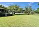 Expansive backyard featuring a lush lawn and screened in porch overlooking the lake at 1204 Joe Henry Wheeler Dr, Dover, FL 33527