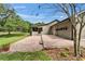 Home's backyard features a brick patio, green lawn, and a view of the home's exterior at 1204 Joe Henry Wheeler Dr, Dover, FL 33527