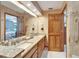 Nicely lit bathroom featuring double sinks, granite countertop, and shower entry at 1204 Joe Henry Wheeler Dr, Dover, FL 33527