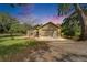 Front exterior showcasing the home's lush lawn, two-car garage, and brick entry walkway at 1204 Joe Henry Wheeler Dr, Dover, FL 33527