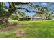 Charming single-story home featuring a screened-in porch, complemented by mature trees and a well-manicured lawn at 1204 Joe Henry Wheeler Dr, Dover, FL 33527