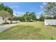 Spacious front yard with lush grass and mature trees, complemented by a white fence and a charming home in the background at 1204 Joe Henry Wheeler Dr, Dover, FL 33527