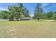 Charming single-story home featuring lush green lawn and mature trees, creating a serene and inviting atmosphere at 1204 Joe Henry Wheeler Dr, Dover, FL 33527