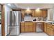 Kitchen with stainless steel fridge and wood cabinets at 1204 Joe Henry Wheeler Dr, Dover, FL 33527
