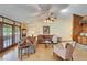 Inviting living room featuring hardwood floors, cozy seating, and a stone fireplace with wood paneling at 1204 Joe Henry Wheeler Dr, Dover, FL 33527