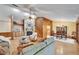 Open living room featuring a stone fireplace, wood paneling, and a view to the dining area at 1204 Joe Henry Wheeler Dr, Dover, FL 33527