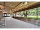 Spacious screened porch with wood floors, ceiling fans, and serene views of the lush backyard and lake at 1204 Joe Henry Wheeler Dr, Dover, FL 33527
