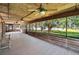 Covered porch with wood ceiling, ceiling fans, and views of the expansive lawn and lake at 1204 Joe Henry Wheeler Dr, Dover, FL 33527