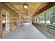 Spacious screened-in porch with wood flooring, ceiling fans, and serene views for outdoor relaxation at 1204 Joe Henry Wheeler Dr, Dover, FL 33527