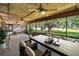 Spacious screened porch with wood ceiling, ceiling fans, and views of the lush yard and lake at 1204 Joe Henry Wheeler Dr, Dover, FL 33527