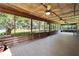 Spacious screened porch with wood floors, ceiling fans, and scenic lake views at 1204 Joe Henry Wheeler Dr, Dover, FL 33527