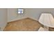 A cozy bedroom with neutral colored carpet, white walls and a window dressed with sheer, white curtains at 12300 Park Blvd # 202, Seminole, FL 33772