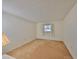 Bedroom with a window dressed with white curtains and neutral carpet and walls at 12300 Park Blvd # 202, Seminole, FL 33772