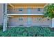Exterior view of a two-story condo building featuring lush greenery and covered walkways at 12300 Park Blvd # 202, Seminole, FL 33772