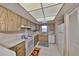 Efficient kitchen space with wood-look cabinetry, white appliances, and tile flooring for easy maintenance at 12300 Park Blvd # 202, Seminole, FL 33772