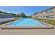 Community pool area with clear blue water surrounded by concrete and a fence for safety at 12300 Park Blvd # 202, Seminole, FL 33772