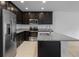 Modern kitchen features stainless steel appliances, dark cabinets, and light granite countertops at 12308 Chaya Ct, Spring Hill, FL 34610