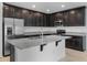 Modern kitchen featuring granite countertops, stainless steel appliances, and dark wood cabinets at 12308 Chaya Ct, Spring Hill, FL 34610