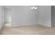 Spacious living room featuring neutral carpet and a modern chandelier at 12308 Chaya Ct, Spring Hill, FL 34610