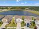 Aerial view of homes with manicured lawns near a serene lake, showing the neighborhood's tranquil setting at 12856 French Market Dr, Riverview, FL 33579