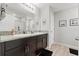 Well-lit bathroom featuring a double vanity with granite countertop and modern fixtures, complemented by wood-look flooring at 12856 French Market Dr, Riverview, FL 33579