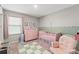 Adorable Bedroom features a cozy rocking chair, crib, and dresser, creating a warm and inviting atmosphere at 12856 French Market Dr, Riverview, FL 33579