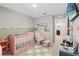 Charming Bedroom with soft colors features a crib, rocking chair, and playful accents for a serene atmosphere at 12856 French Market Dr, Riverview, FL 33579