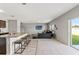 Open concept living space with a kitchen island and barstool seating next to the carpeted living room at 12856 French Market Dr, Riverview, FL 33579