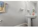 Clean and simple powder room features a pedestal sink, a modern faucet, and a neutral color palette at 12856 French Market Dr, Riverview, FL 33579