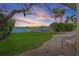 A scenic backyard view with manicured lawn, mature trees, and waterfront access at 1344 Monterey Ne Blvd, St Petersburg, FL 33704