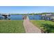 Backyard with a well-maintained lawn, brick walkway leading to a private boat dock at 1344 Monterey Ne Blvd, St Petersburg, FL 33704