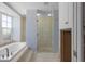Bathroom features a soaking tub, large window, walk-in shower, and tile flooring in need of repairs at 1344 Monterey Ne Blvd, St Petersburg, FL 33704