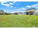 Large, grassy backyard offering ample space and views of neighboring houses and a pond at 18185 Cortes Creek Blvd, Spring Hill, FL 34610