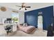 Cozy bedroom with a vibrant blue accent wall, desk area, and a full-length mirror at 18185 Cortes Creek Blvd, Spring Hill, FL 34610