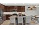 Modern kitchen with granite counters, dark cabinets, and island with seating at 18185 Cortes Creek Blvd, Spring Hill, FL 34610