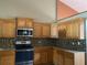 Well-appointed kitchen with modern appliances, stylish backsplash, granite countertops, and wood cabinets at 18724 Geraci Rd, Lutz, FL 33548