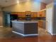 Modern kitchen with granite counters, stainless appliances, center island, and wooden cabinets at 18724 Geraci Rd, Lutz, FL 33548