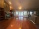 Spacious living room featuring hardwood floors, stone fireplace, built-in shelving, and double doors to the pool at 18724 Geraci Rd, Lutz, FL 33548